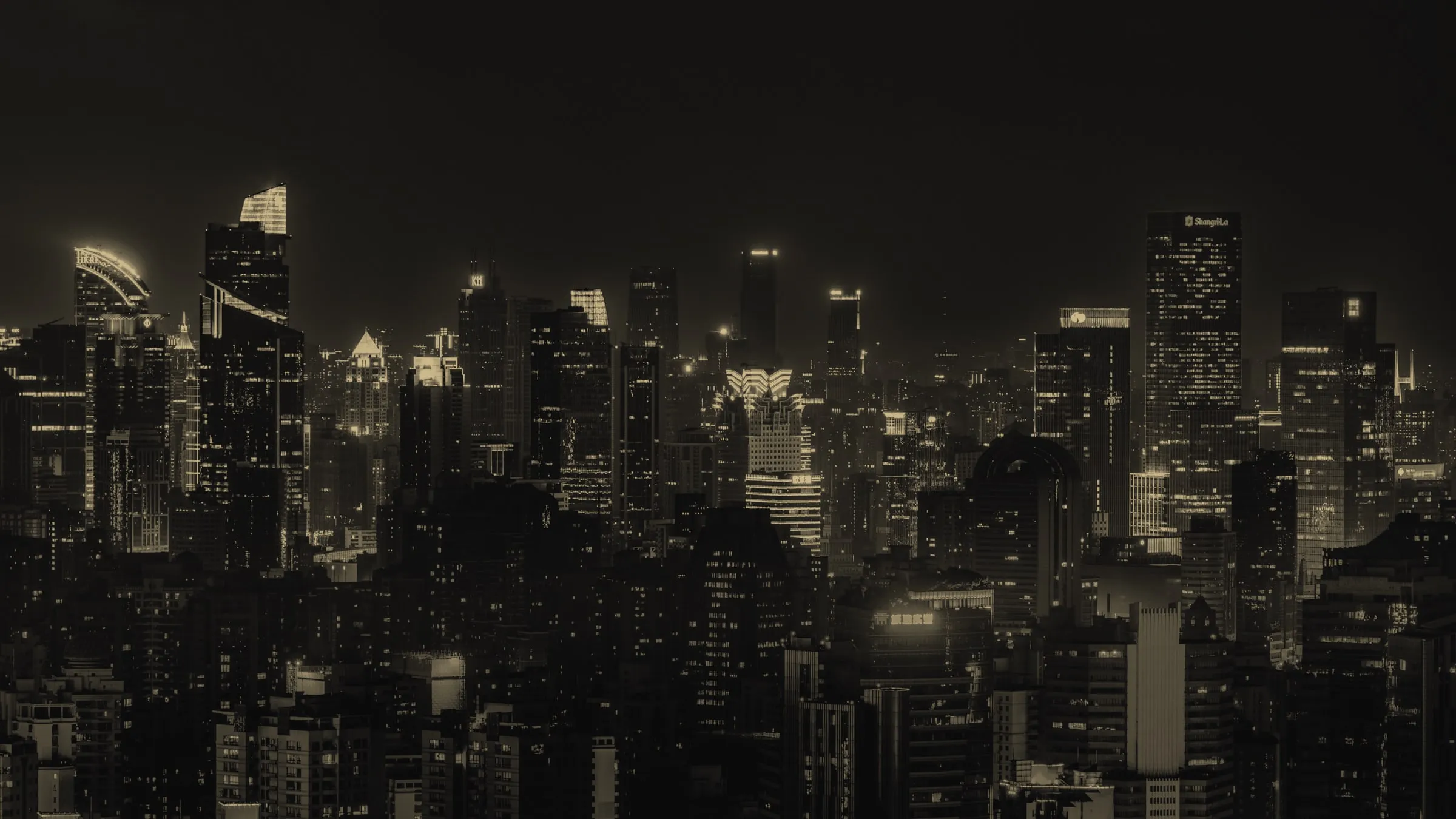 A financial district skyline at night, towers lit against a dark sky.